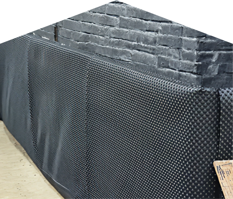 Exterior basement waterproofing completed by Romaniuk , showing a sealed foundation wall with dimpled waterproof membrane partially installed on a brick surface, preventing moisture infiltration. Exterior basement waterproofing completed by Romaniuk , showing a sealed foundation wall with dimpled waterproof membrane partially installed on a brick surface, preventing moisture infiltration.