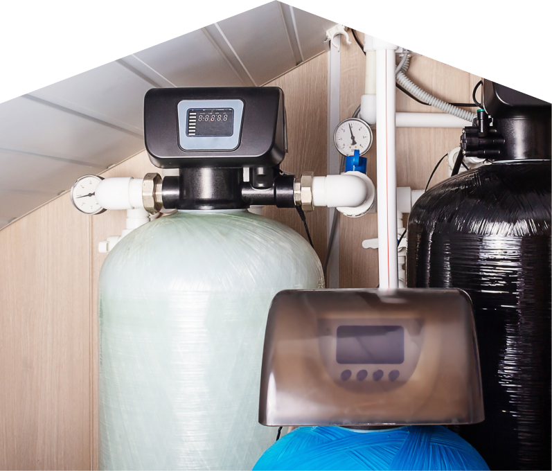 Romaniuk stra home water filtration system featuring resin tanks, digital control heads, pressure gauges, and connected piping in a utility room. Romaniuk home water filtration system featuring resin tanks, digital control heads, pressure gauges, and connected piping in a utility room.