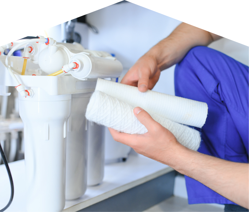 Romaniuk water filtration specialist replacing filter cartridges on a reverse osmosis water system installed under a sink. Romaniuk water filtration specialist replacing filter cartridges on a reverse osmosis water system installed under a sink.