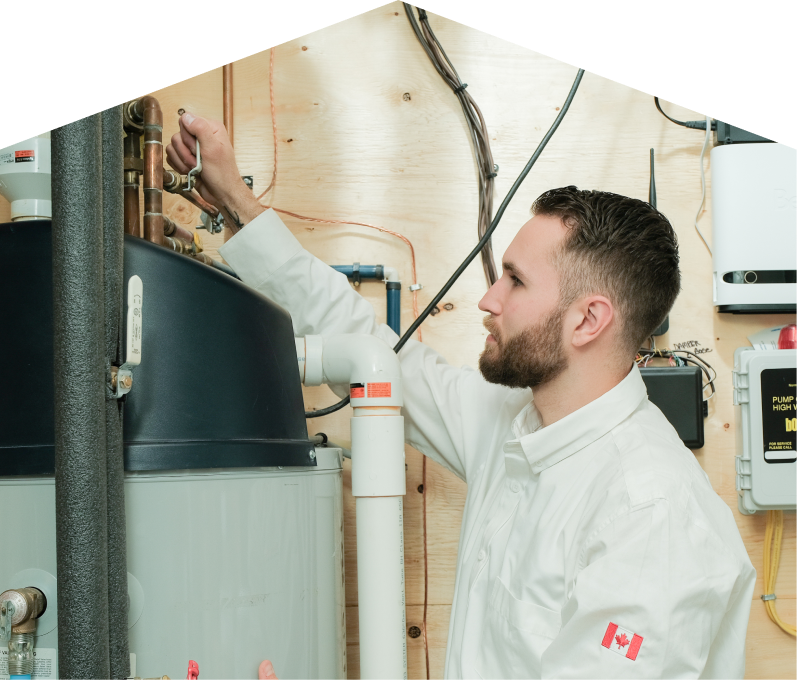 Romaniuk water heater specialist adjusts piping on a large residential unit during a repair service, with exposed wood paneling and mounted utility components in the background. Romaniuk water heater specialist adjusts piping on a large residential unit during a repair service, with exposed wood paneling and mounted utility components in the background.
