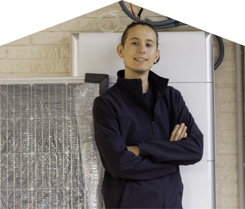 Romaniuk specialist standing confidently with arms crossed beside newly delivered system components, including a wrapped panel and wall-mounted utility unit. Romaniuk specialist standing confidently with arms crossed beside newly delivered system components, including a wrapped panel and wall-mounted utility unit.