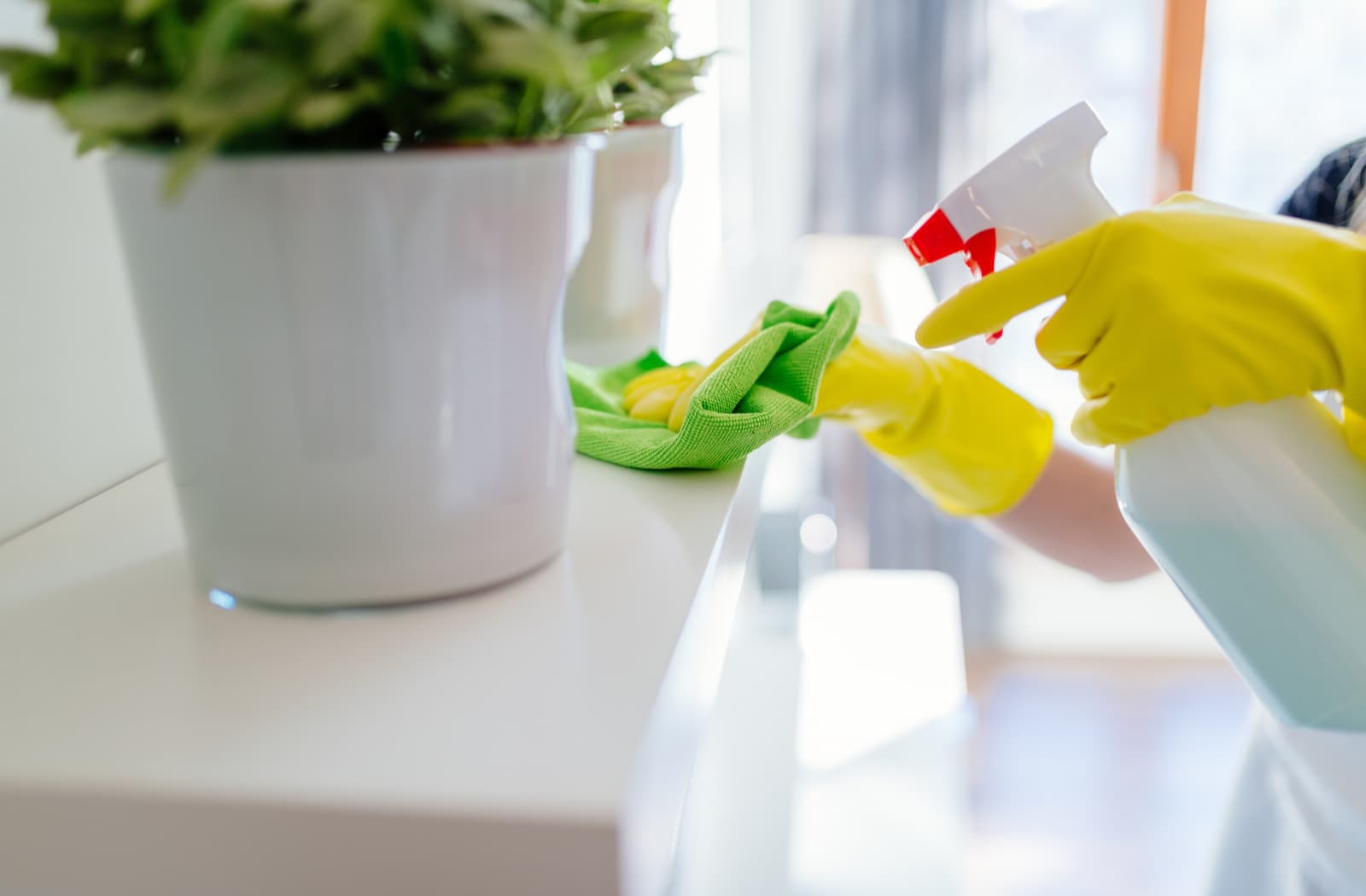 Person cleaning a mantle with a green cloth.